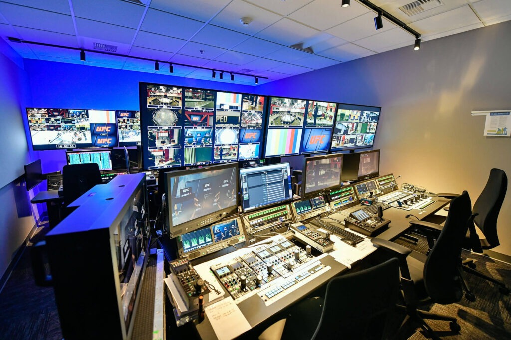 Operator working in a broadcast control room with multiple screens, illustrating the news publishing infrastructure of an international media network.
